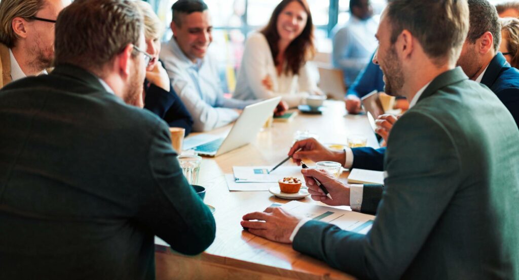 executives and business people talking happily in a group